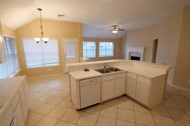 a kitchen that has a sink a stove top oven a counter space and a window