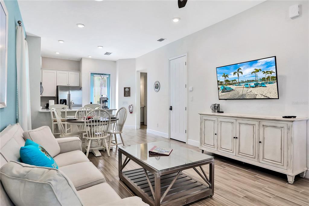 8038 Surf Street Kissimmee, FL 34747 - Photo 2 of 81 a living room with furniture a flat screen tv and kitchen view
