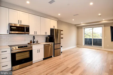 a kitchen with stainless steel appliances a stove a sink and a microwave