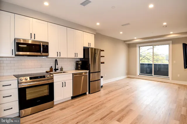 a kitchen with stainless steel appliances a stove a sink and a microwave