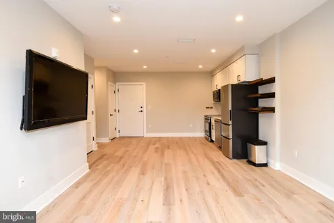 a view of a living room with a flat screen tv and refrigerator