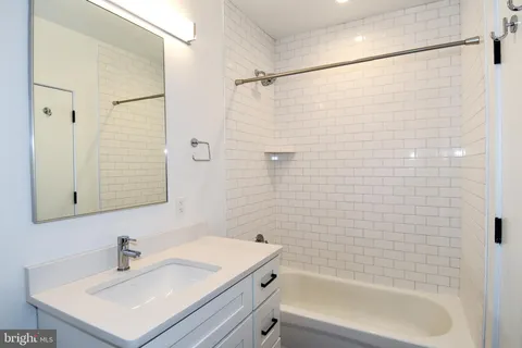 a bathroom with a white sink a shower and a mirror