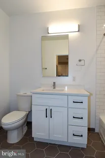 a bathroom with a toilet a sink and mirror