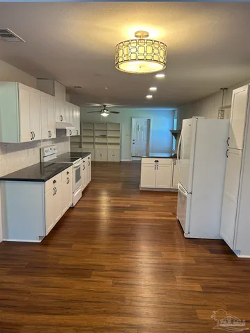a view of a hallway with a wooden ceiling fan