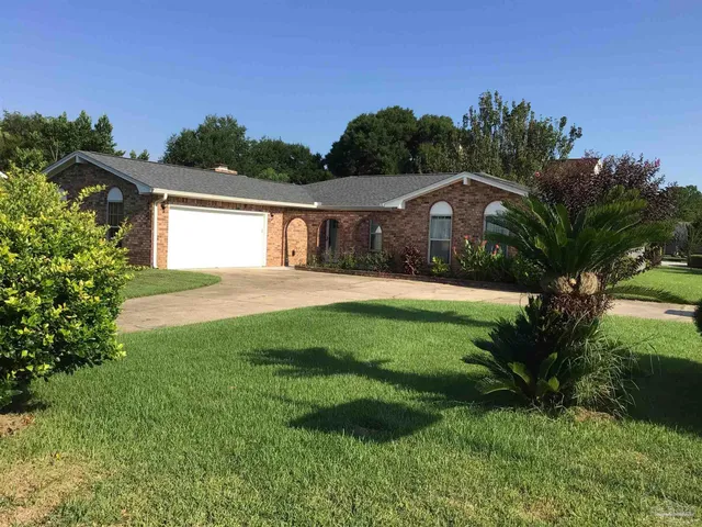 a front view of a house with yard and green space