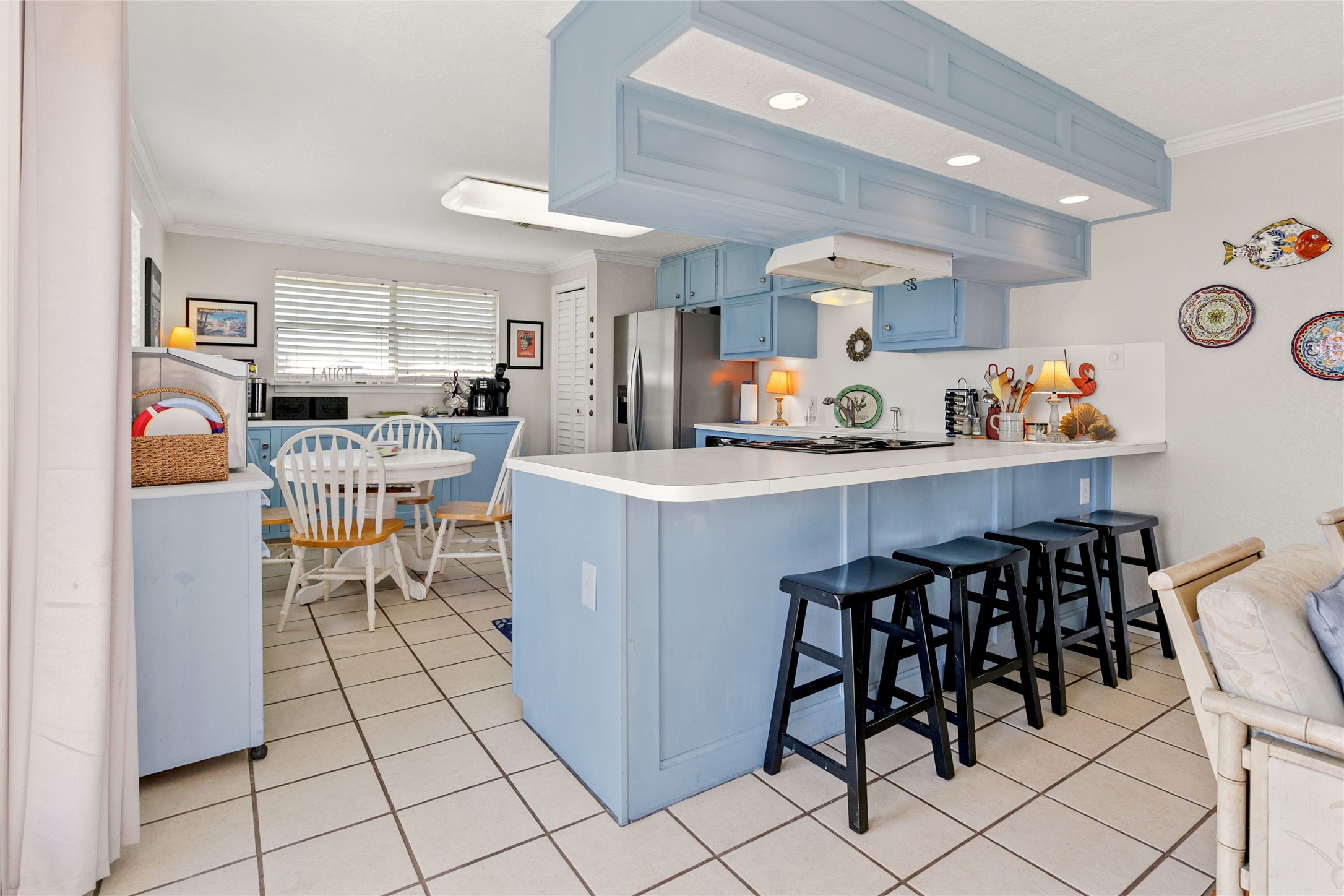 12911 Jolly Roger Drive Freeport, TX 77541 - Photo 11 of 41 a kitchen with stainless steel appliances kitchen island granite countertop a table chairs and a refrigerator