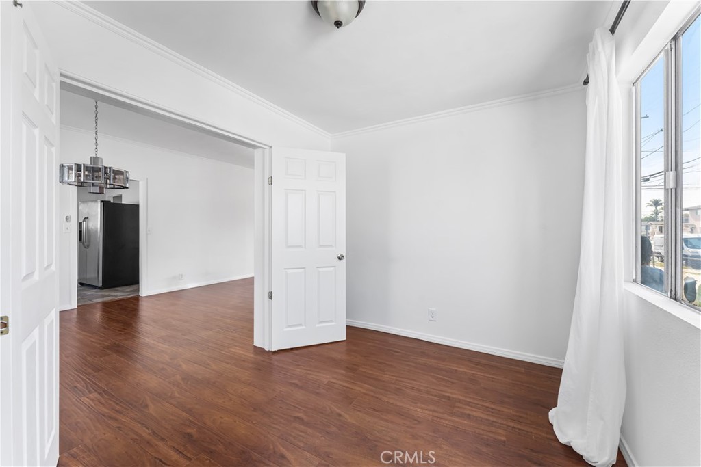 1178 Spence Street Los Angeles, CA 90023 - Photo 12 of 36 a view of an empty room with wooden floor and a window