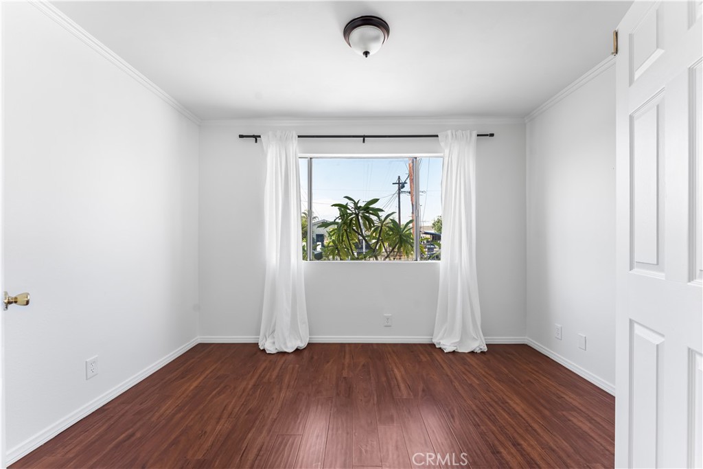 1178 Spence Street Los Angeles, CA 90023 - Photo 13 of 36 an empty room with wooden floor and windows
