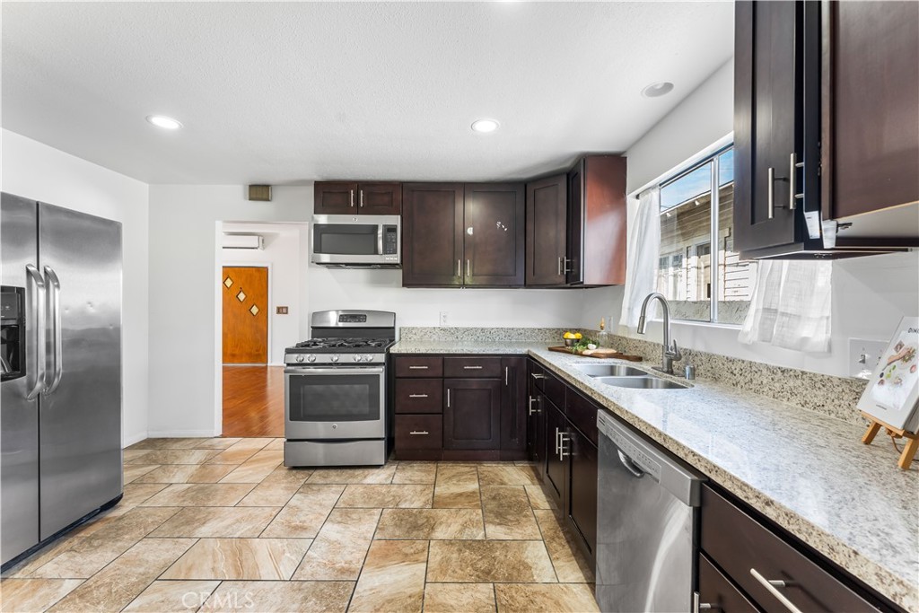 1178 Spence Street Los Angeles, CA 90023 - Photo 29 of 36 a kitchen with stainless steel appliances granite countertop a sink stove and refrigerator