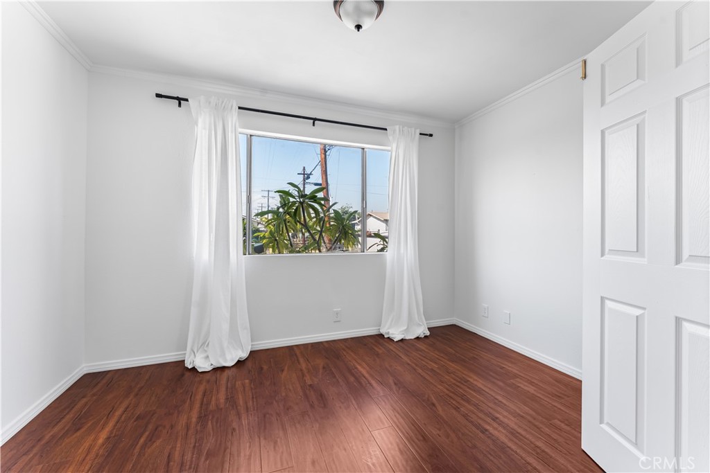 1178 Spence Street Los Angeles, CA 90023 - Photo 33 of 36 an empty room with wooden floor and windows