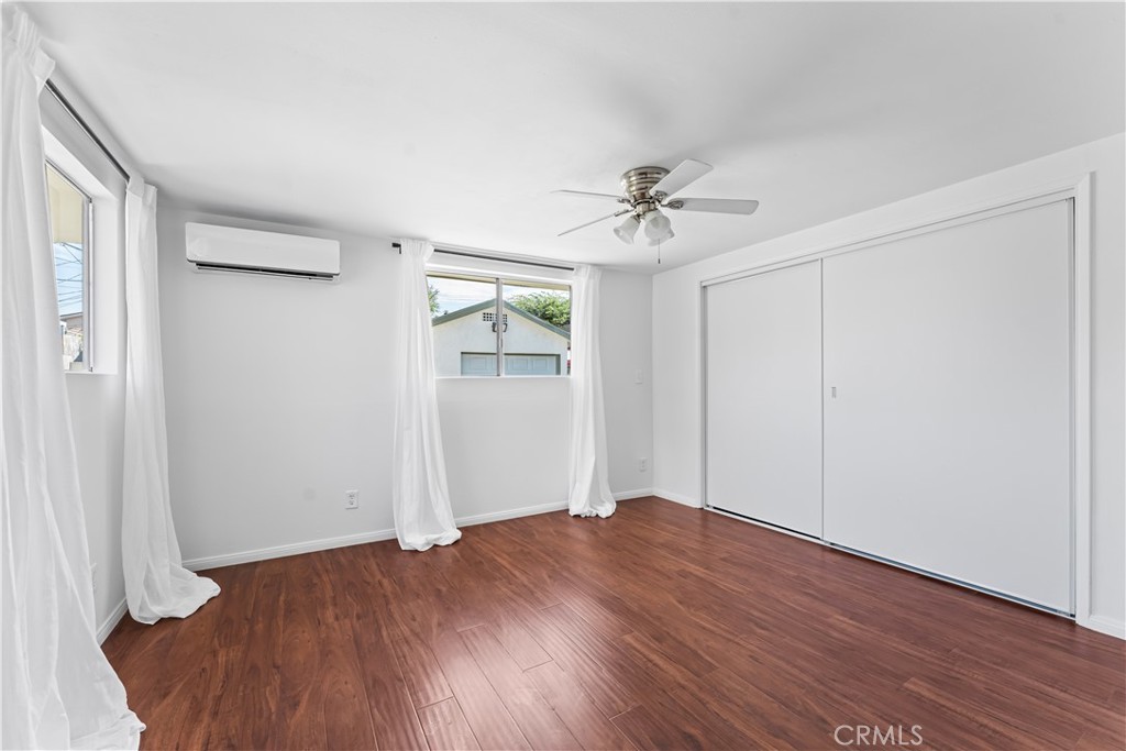 1178 Spence Street Los Angeles, CA 90023 - Photo 34 of 36 an empty room with wooden floor and ceiling fan