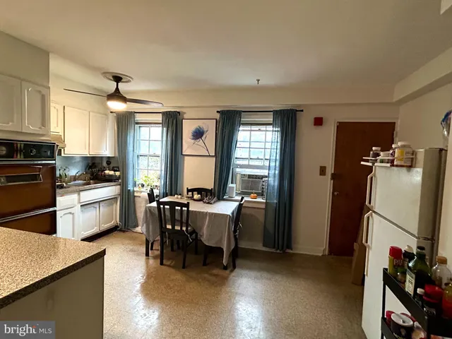 a kitchen with refrigerator and chairs
