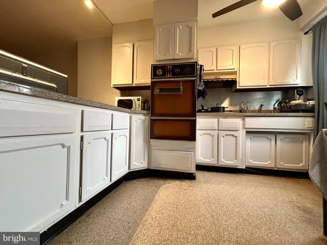 a kitchen with white cabinets and white appliances
