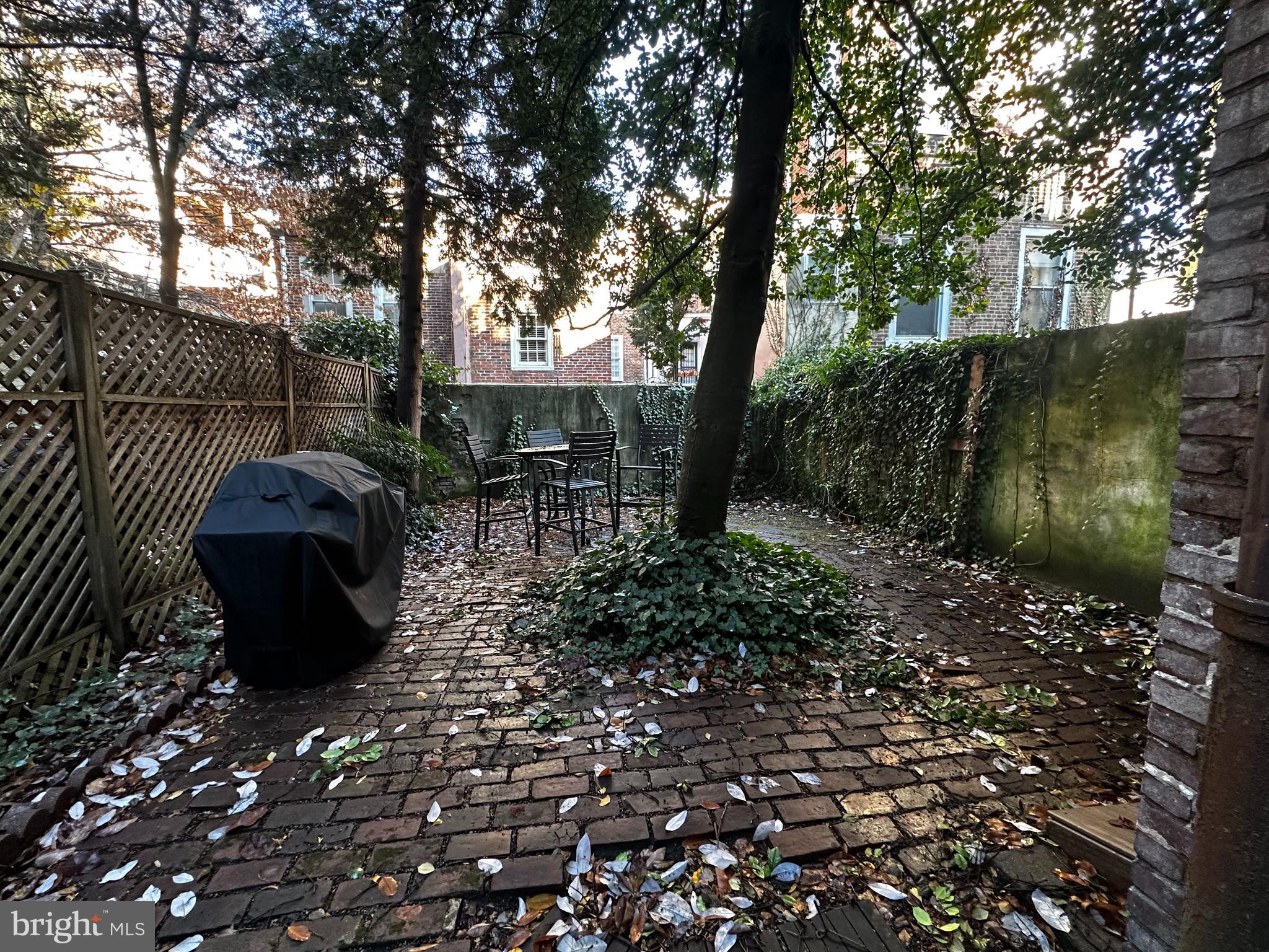 249 Pine Street, Unit 3 Philadelphia, PA 19106 - Photo 7 of 20 a view of a backyard with table and chairs potted plants and large tree