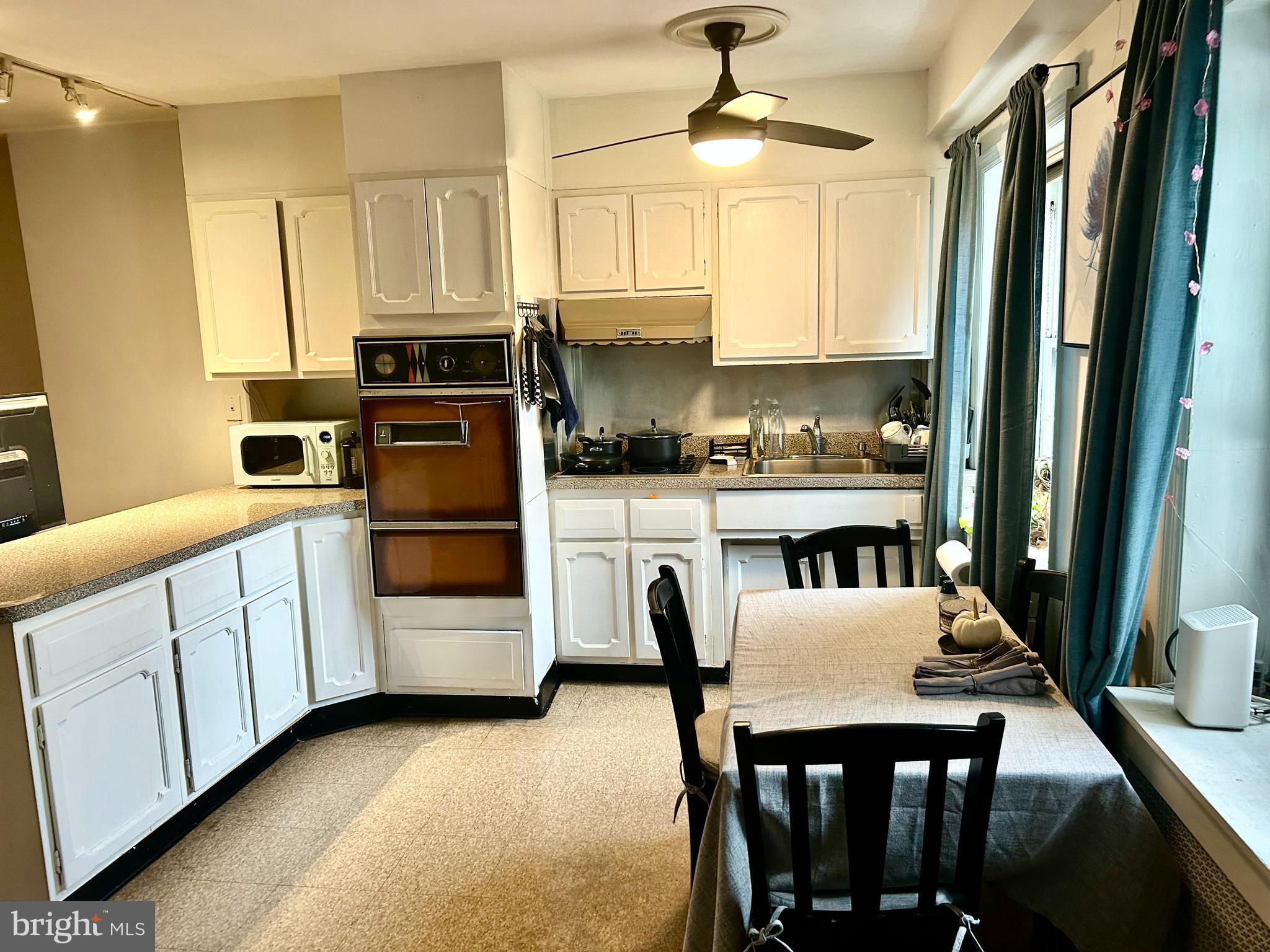 249 Pine Street, Unit 3 Philadelphia, PA 19106 - Photo 9 of 20 a kitchen with stainless steel appliances a table chairs and a refrigerator