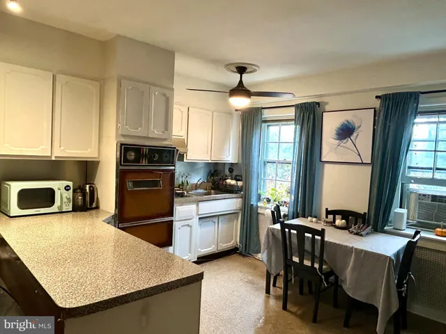 a kitchen with stainless steel appliances granite countertop a stove top oven a sink a dining table and chairs