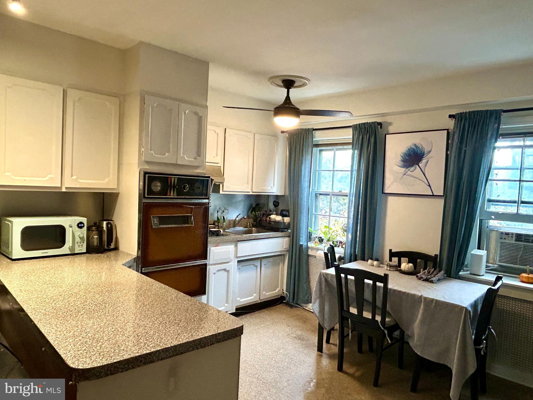 249 Pine Street, Unit 3 Philadelphia, PA 19106 - Photo 10 of 20 a kitchen with stainless steel appliances granite countertop a stove top oven a sink a dining table and chairs