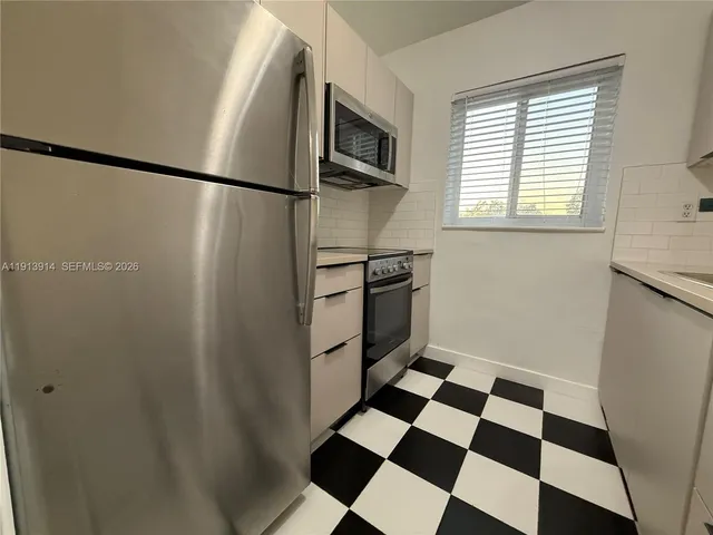 a kitchen with a refrigerator a sink and a window
