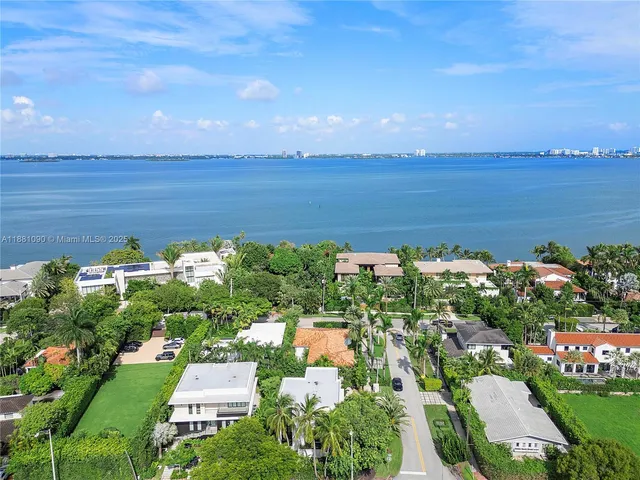 an aerial view of a house with a yard and lake view