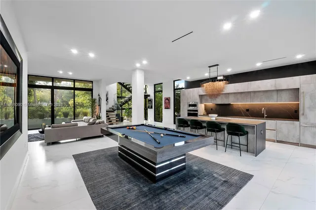 a living room with furniture a table and large windows