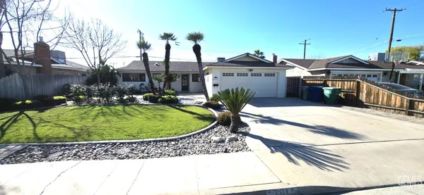 a view of a house with a yard and sitting area