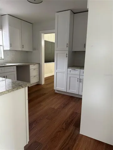 a kitchen with wooden floors and cabinets