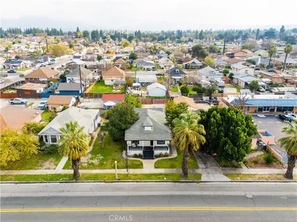 an aerial view of residential houses with outdoor space and parking