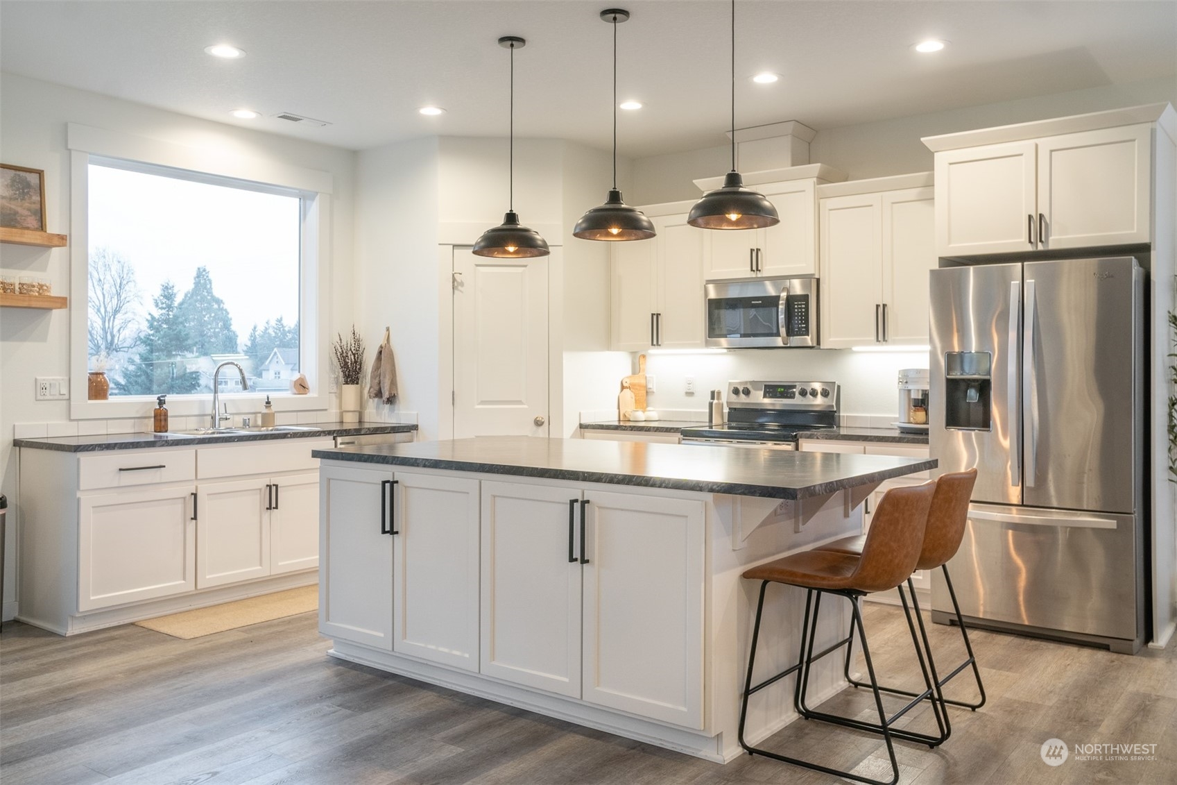703 D Street Vader, WA 98593 - Photo 14 of 39 a kitchen with stainless steel appliances granite countertop a refrigerator a sink dishwasher a stove and white cabinets with wooden floor