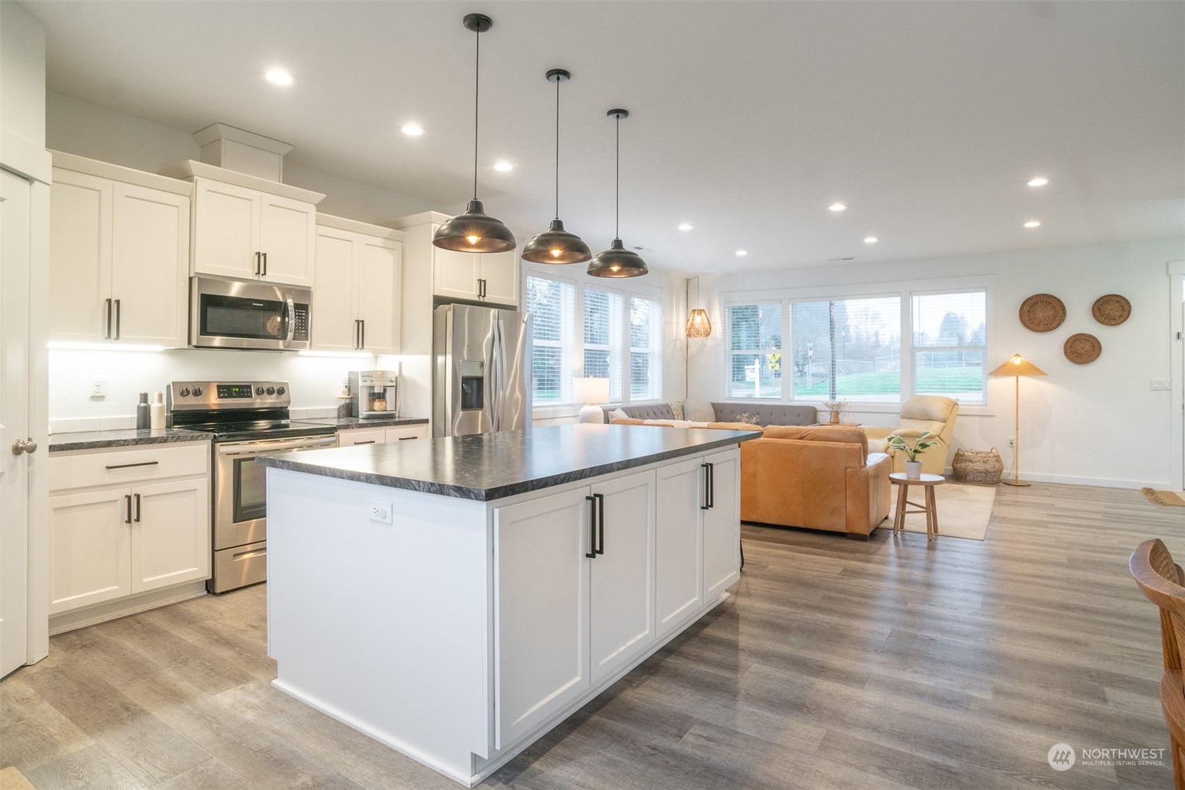 703 D Street Vader, WA 98593 - Photo 20 of 39 a large kitchen with stainless steel appliances kitchen island granite countertop a stove a sink a refrigerator and a dining table with wooden floor