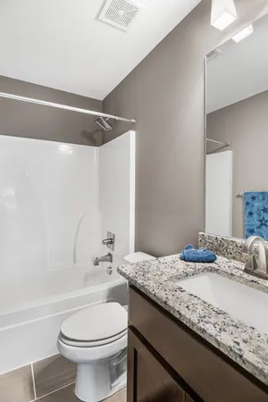 a bathroom with a granite countertop sink toilet and shower
