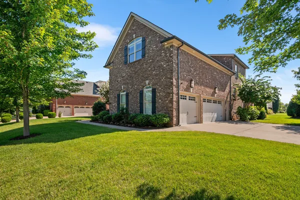 a front view of a house with a yard and trees