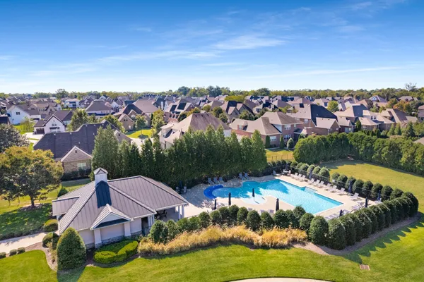 an aerial view of residential houses with outdoor space and swimming pool