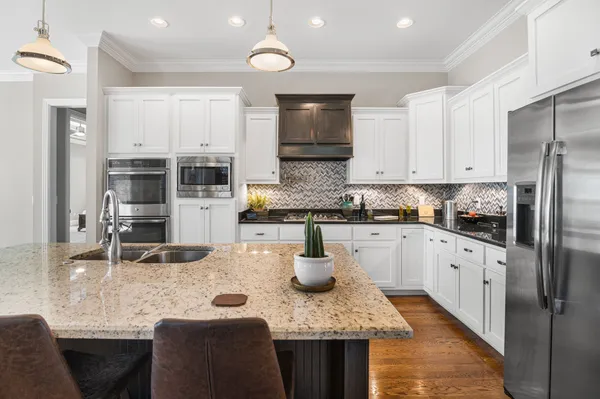 a kitchen with stainless steel appliances granite countertop a stove refrigerator and cabinets