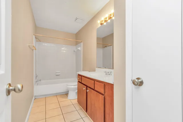 a bathroom with a granite countertop sink a toilet and shower