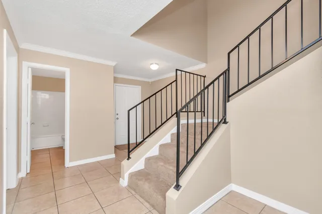 a view of staircase with railing and white walls