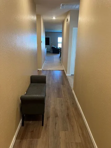 a hallway with wooden floor and furniture