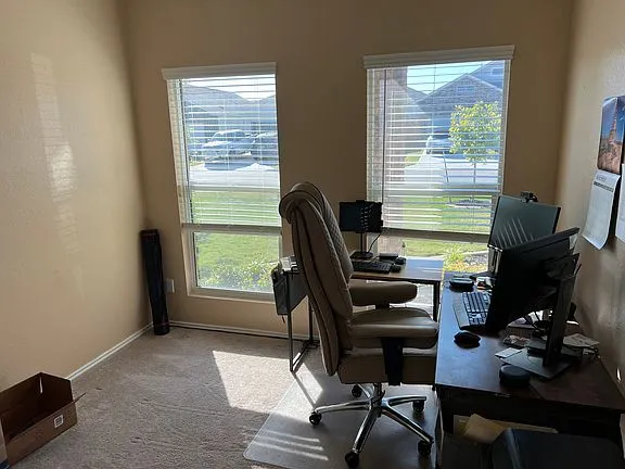 a view of a workspace with furniture and a window