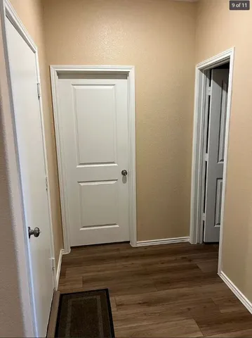 an empty room with wooden floor and entrance