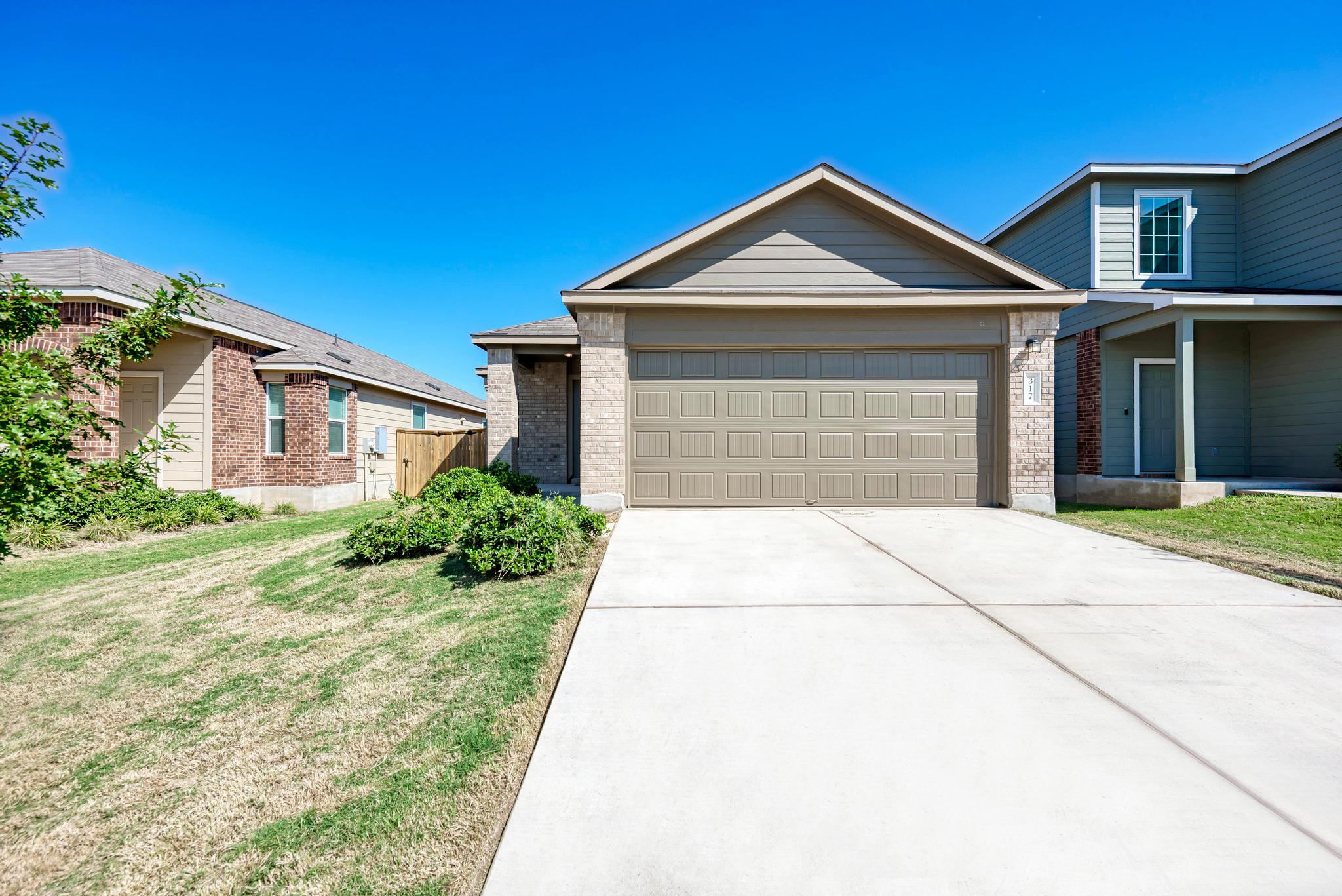 317 Perfect World Loop Jarrell, TX 76537 - Photo 1 of 1 a front view of a house with a yard and garage