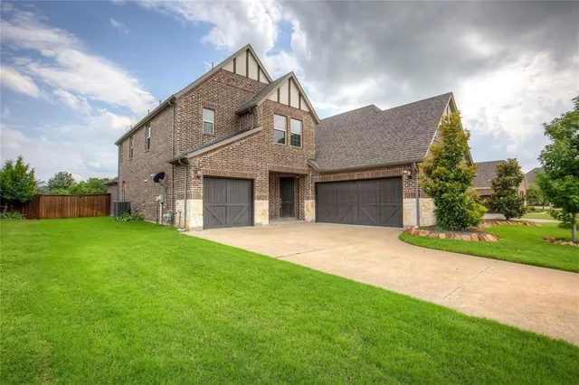 a front view of a house with a garden and yard
