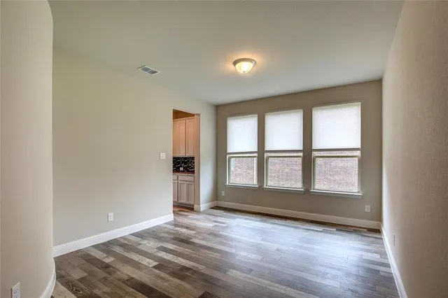 a large hall with a large window and wooden floors