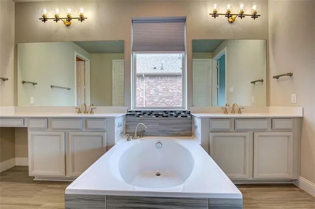 a bathroom with a sink a large mirror and a bathtub
