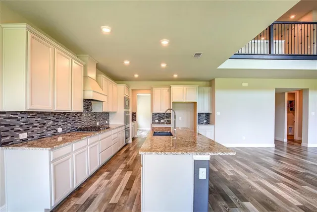 a view of kitchen with granite countertop cabinets and refrigerator
