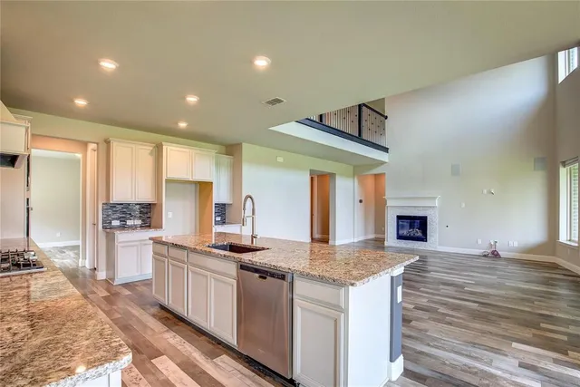 a kitchen with stainless steel appliances granite countertop a stove a sink and a refrigerator