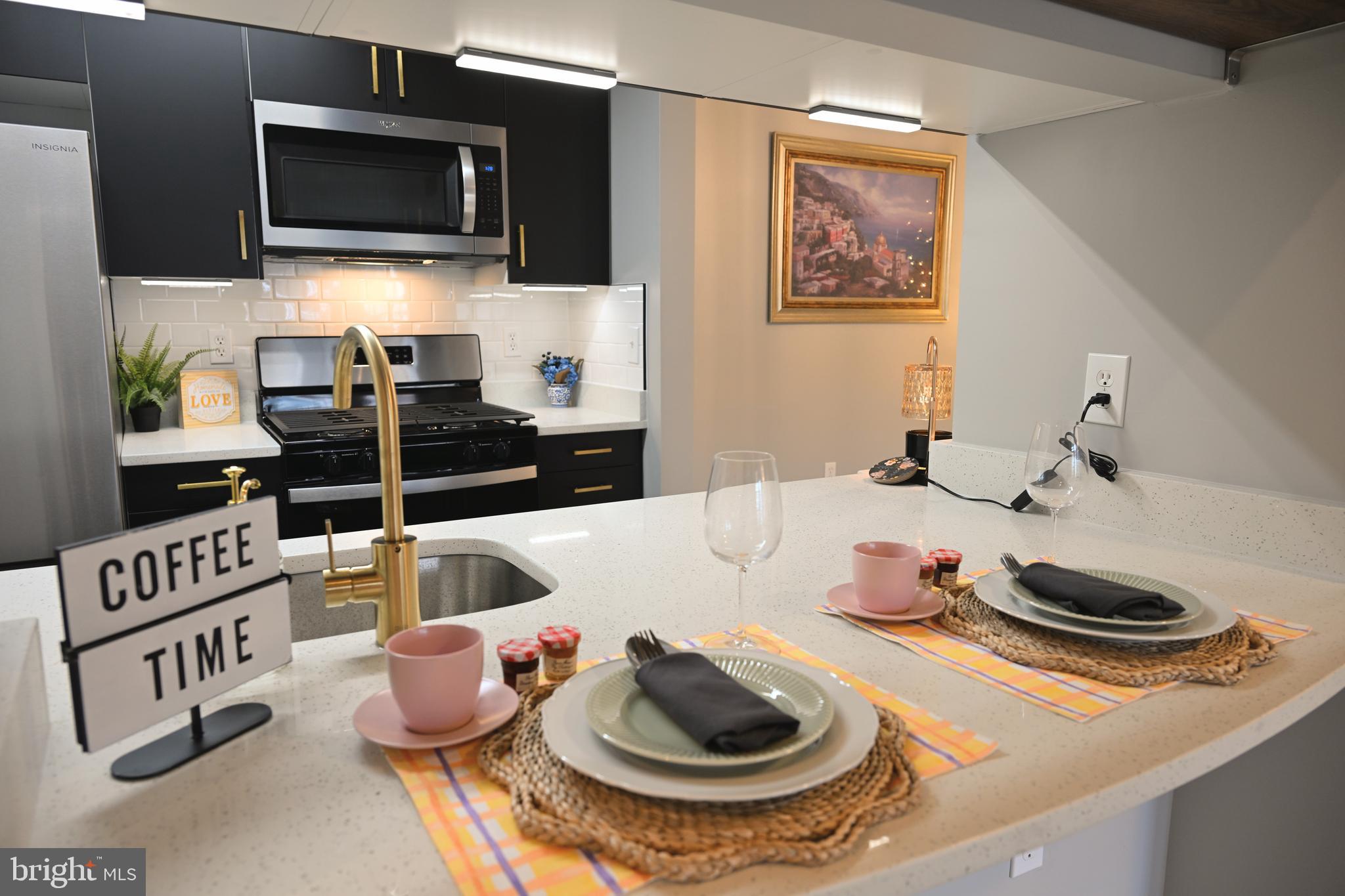 20965 Timber Ridge Terrace, Unit 304 Ashburn, VA 20147 - Photo 1 of 61 a kitchen with a sink and a stove top oven
