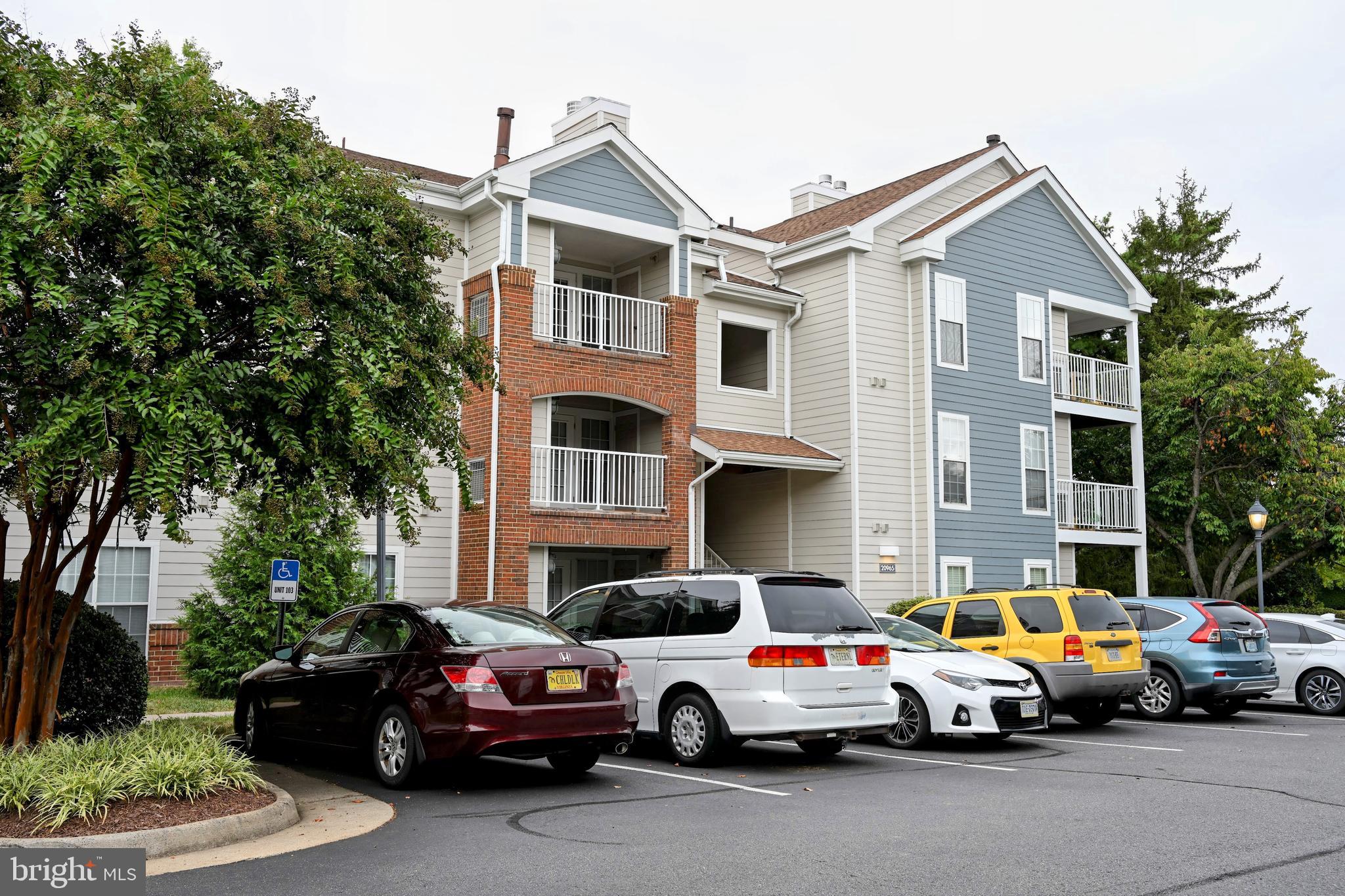 20965 Timber Ridge Terrace, Unit 304 Ashburn, VA 20147 - Photo 7 of 61 a view of cars parked in front of a house