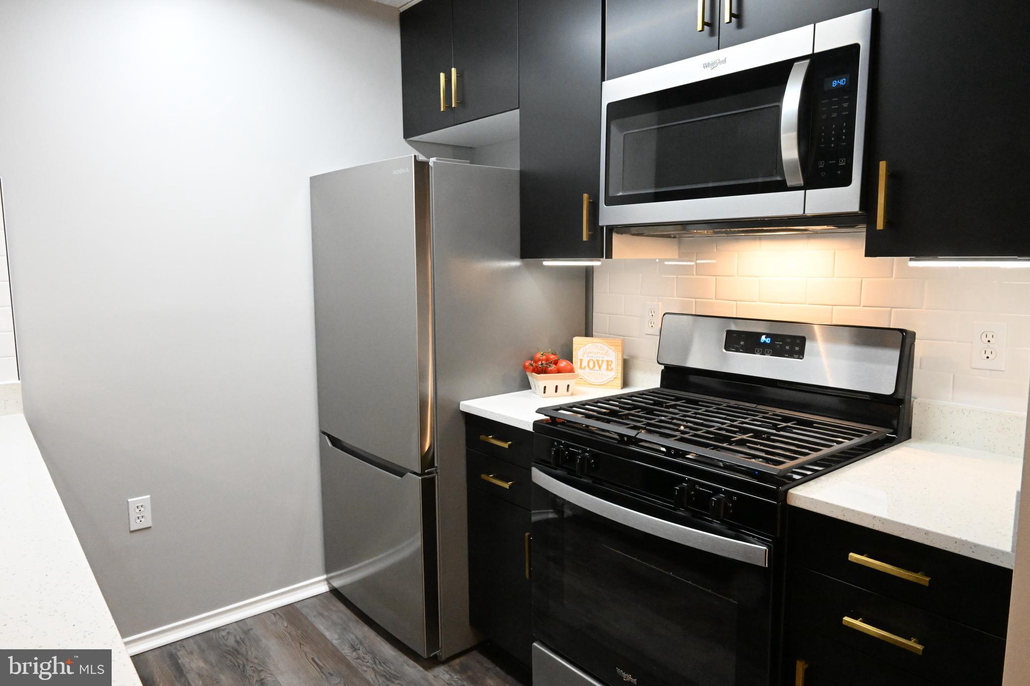 20965 Timber Ridge Terrace, Unit 304 Ashburn, VA 20147 - Photo 9 of 61 a kitchen with stainless steel appliances a stove microwave and refrigerator