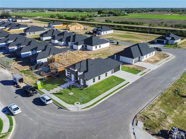 an aerial view of a house with a garden and lake view