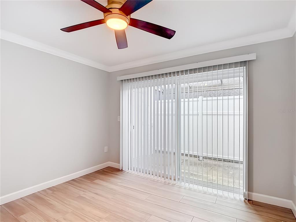 4536 Mitcher Road New Port Richey, FL 34652 - Photo 16 of 46 an empty room with wooden floor chandelier fan and windows