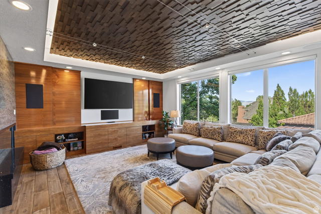 12308 Mariah Circle Draper, UT 84020 - Photo 24 of 293 Living area with floor-to-ceiling windows, a wood-paneled entertainment wall with integrated cabinetry, and a textured ceiling design